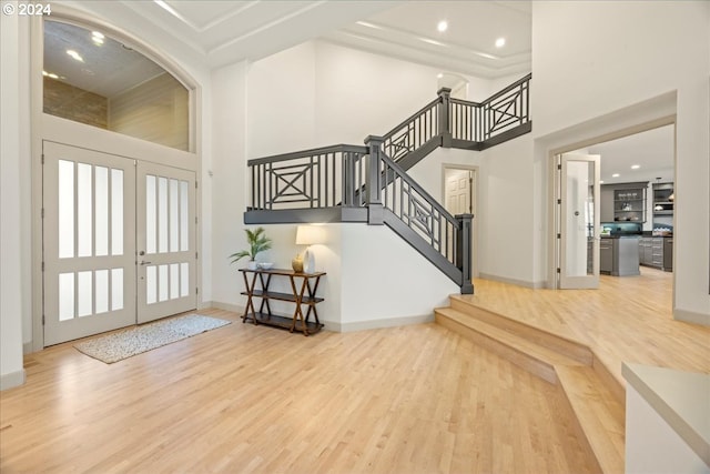 entryway featuring a high ceiling, french doors, and hardwood / wood-style floors