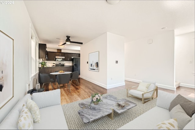 living room with ceiling fan and light wood-type flooring