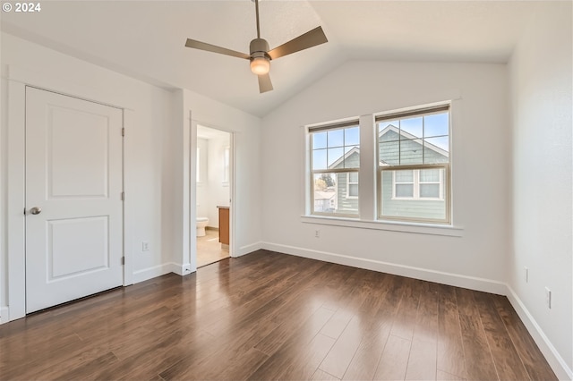 unfurnished bedroom with connected bathroom, ceiling fan, dark hardwood / wood-style flooring, and vaulted ceiling