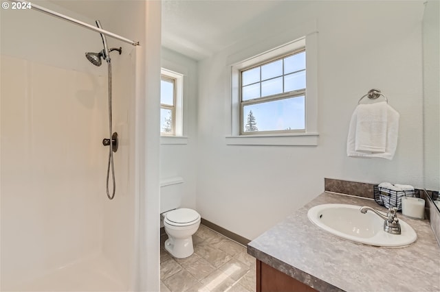 bathroom featuring vanity, toilet, and a shower