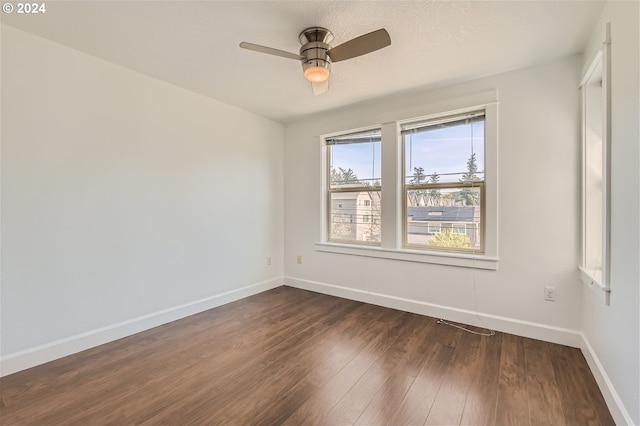 unfurnished room featuring ceiling fan and dark wood-type flooring