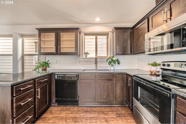 kitchen featuring dark brown cabinetry, sink, stainless steel appliances, dark hardwood / wood-style flooring, and a textured ceiling