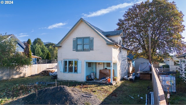 back of property featuring a storage unit