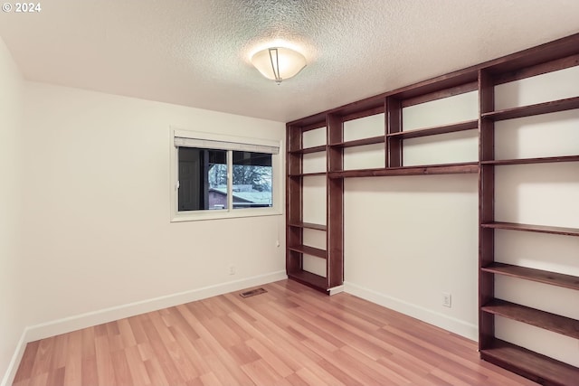 unfurnished bedroom with a textured ceiling and light hardwood / wood-style flooring