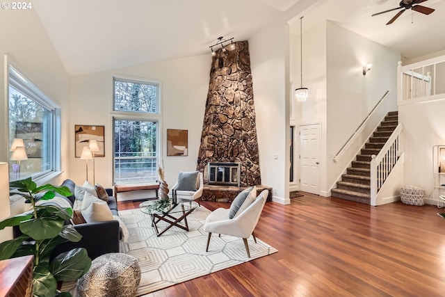 living room featuring a wood stove, ceiling fan, dark hardwood / wood-style flooring, and high vaulted ceiling