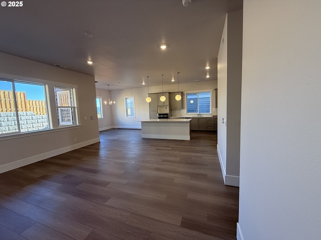 unfurnished living room featuring dark hardwood / wood-style flooring and a chandelier