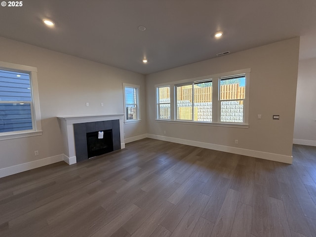 unfurnished living room featuring a tile fireplace and hardwood / wood-style flooring