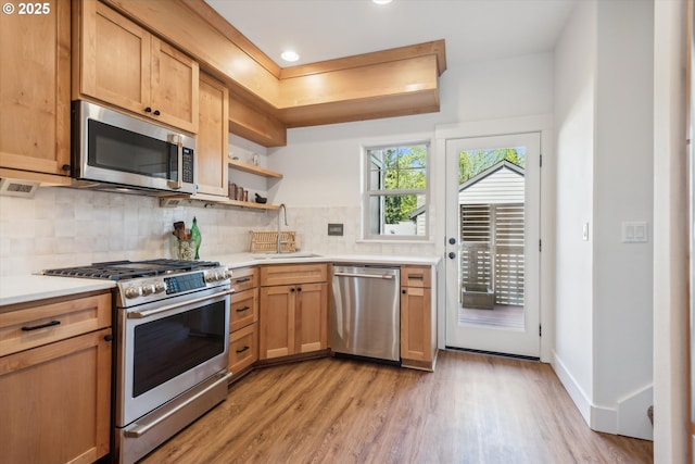 19639 SW Blackbear Ct, Beaverton, OR 97006 - kitchen with appliances with stainless steel finishes, a sink, open shelves, light wood-style floors, and light countertops