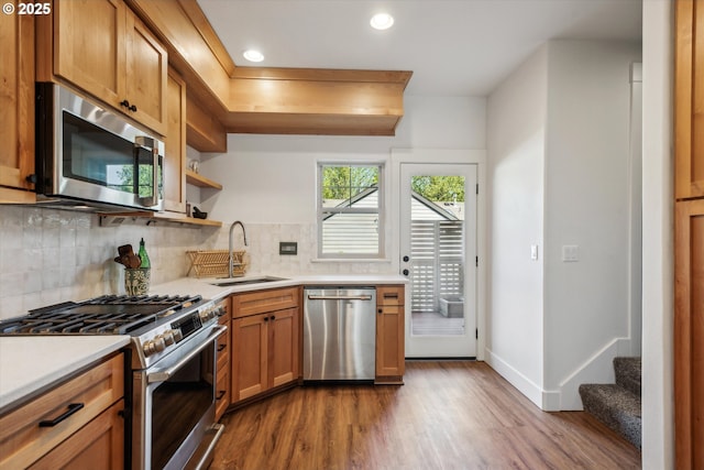 19639 SW Blackbear Ct, Beaverton, OR 97006 - kitchen featuring appliances with stainless steel finishes, a sink, wood finished floors, backsplash, and open shelves