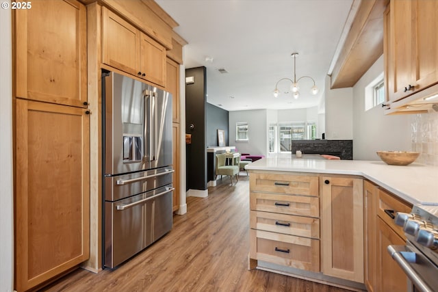 19639 SW Blackbear Ct, Beaverton, OR 97006 - kitchen featuring stainless steel fridge, a peninsula, stove, and light countertops