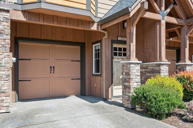 19639 SW Blackbear Ct, Beaverton, OR 97006 - doorway to property with a garage, driveway, a shingled roof, and stone siding