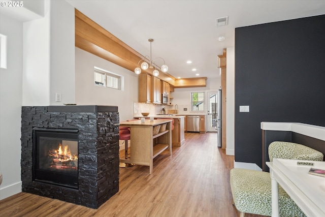 19639 SW Blackbear Ct, Beaverton, OR 97006 - living room with light wood-style floors, a fireplace, recessed lighting, and baseboards