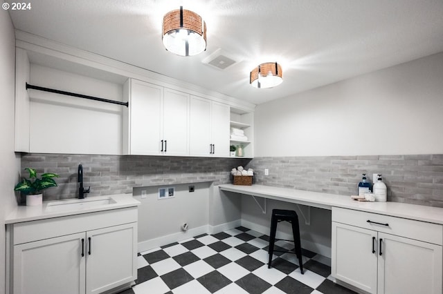 laundry area featuring washer hookup, sink, cabinets, and hookup for an electric dryer