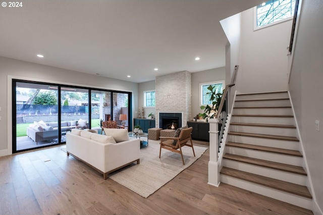 living room featuring light wood-type flooring and a large fireplace