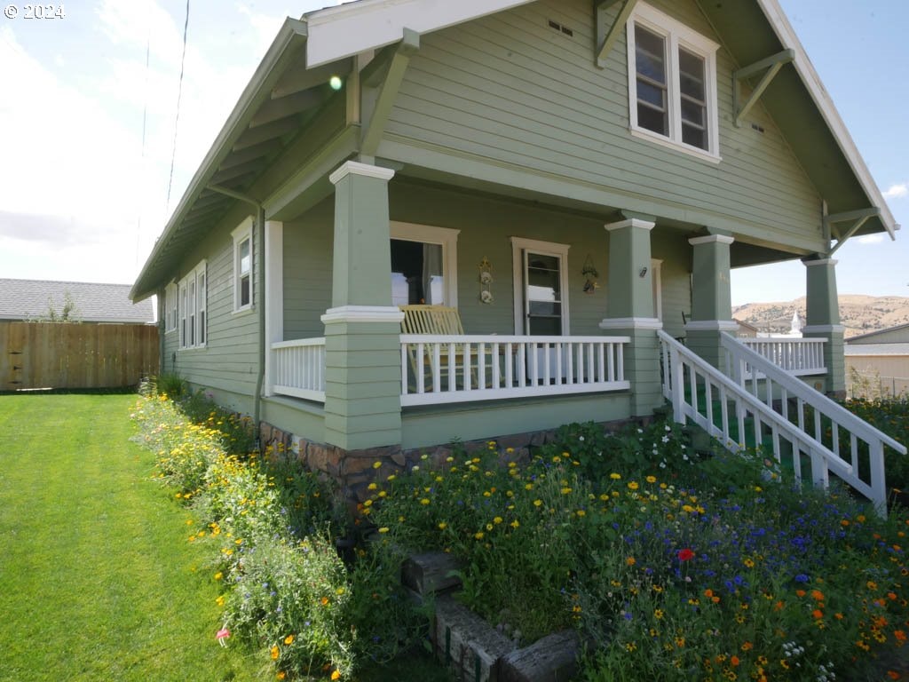 view of front of property featuring covered porch and a front yard