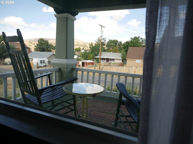 balcony featuring covered porch and a mountain view