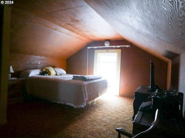 carpeted bedroom with lofted ceiling