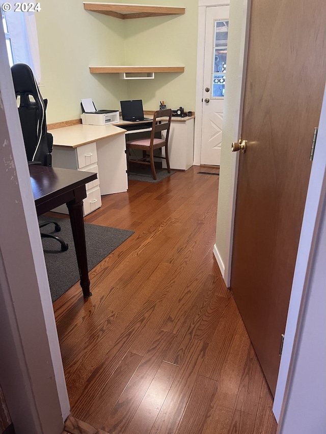 office area with wood-type flooring and built in desk