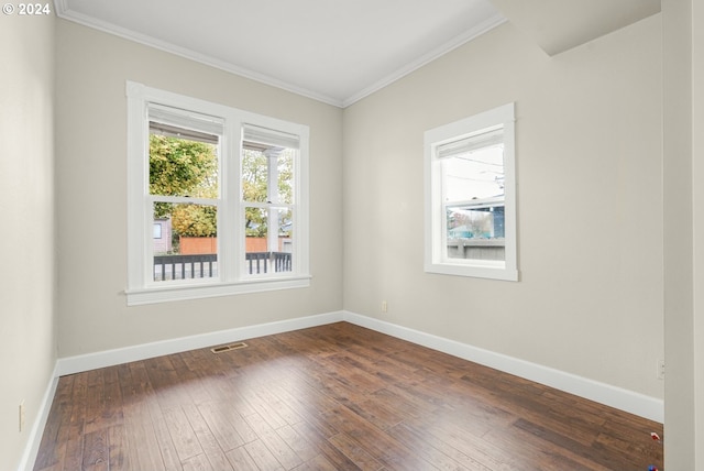 spare room featuring dark hardwood / wood-style flooring and crown molding