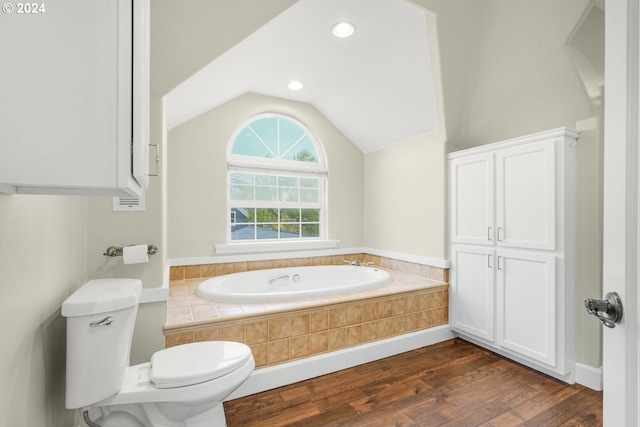 bathroom with toilet, lofted ceiling, wood-type flooring, and a relaxing tiled tub