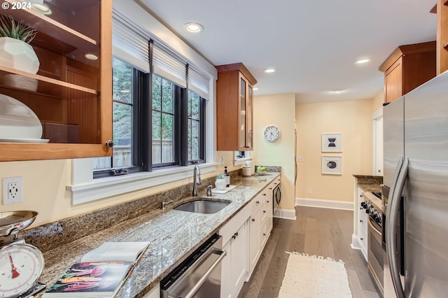 kitchen featuring dark hardwood / wood-style floors, stainless steel appliances, sink, light stone countertops, and white cabinets