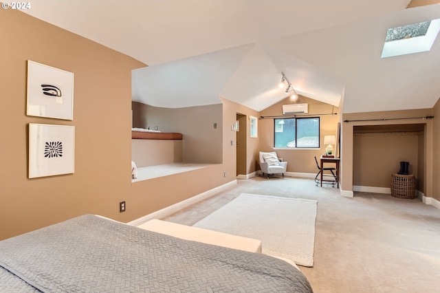 carpeted bedroom with a wall mounted AC and vaulted ceiling with skylight