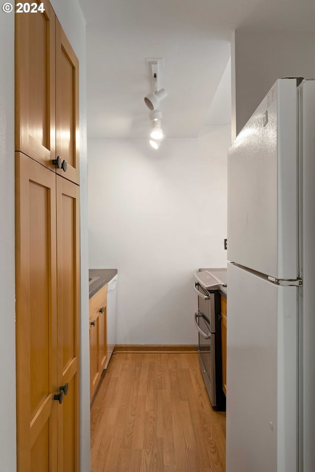 kitchen featuring light hardwood / wood-style flooring, stainless steel electric stove, and white refrigerator