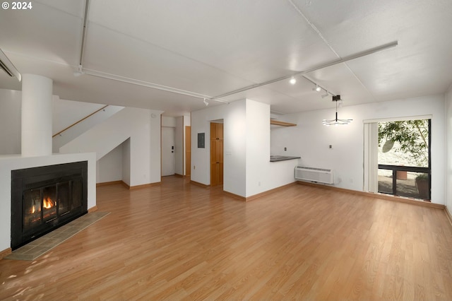 unfurnished living room with track lighting and light hardwood / wood-style floors