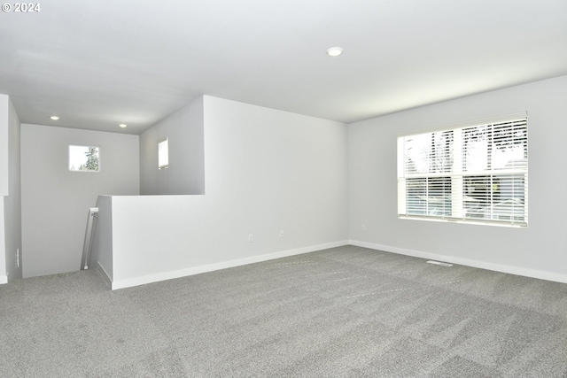 carpeted spare room featuring visible vents, baseboards, and recessed lighting