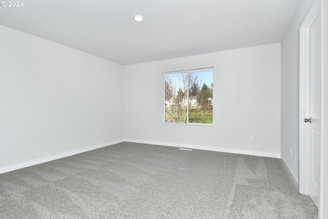 carpeted spare room featuring baseboards