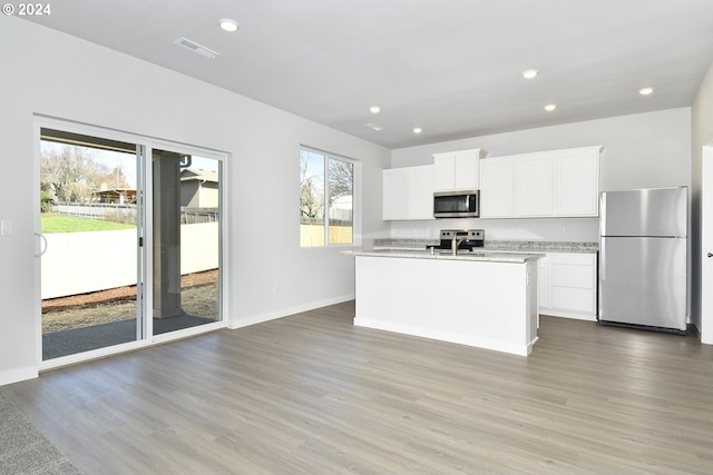 kitchen featuring a sink, appliances with stainless steel finishes, light countertops, and wood finished floors