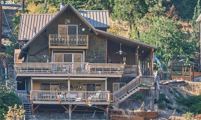 back of house with ceiling fan and a balcony