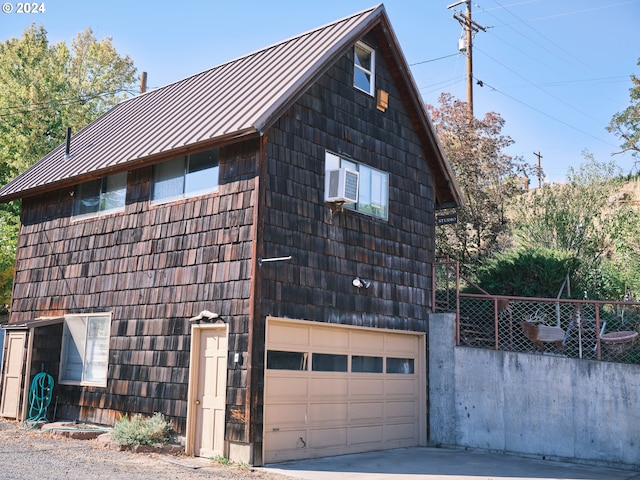 view of property exterior with a garage and cooling unit