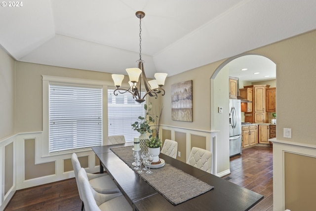 dining space with dark hardwood / wood-style floors, an inviting chandelier, and lofted ceiling