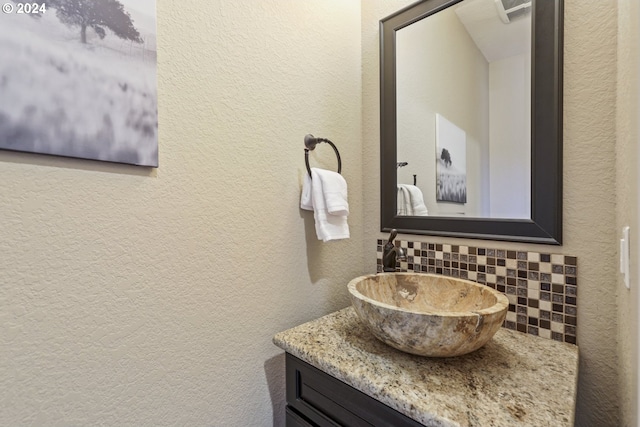 bathroom with vanity and tasteful backsplash