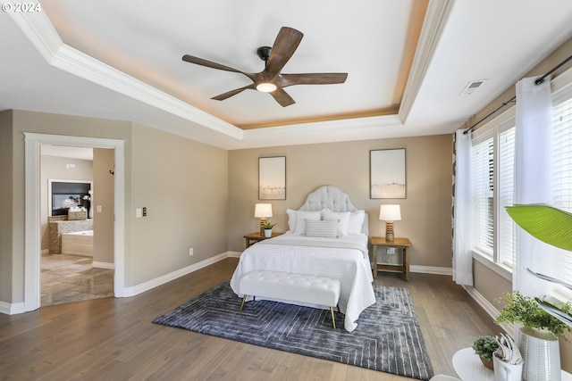 bedroom featuring wood-type flooring, a tray ceiling, and ceiling fan