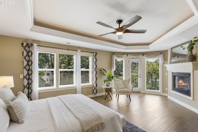 bedroom with a raised ceiling, access to exterior, ceiling fan, and hardwood / wood-style flooring