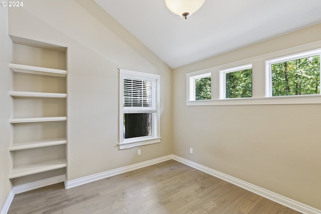 unfurnished room with lofted ceiling and light hardwood / wood-style flooring