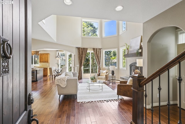 living room featuring dark wood-type flooring and a high ceiling