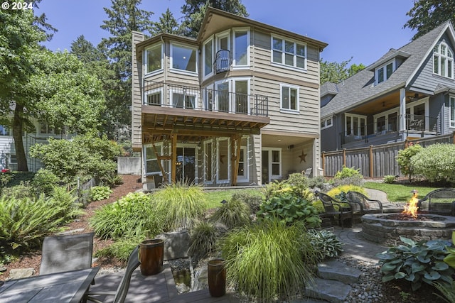 back of house with a balcony, an outdoor fire pit, and a patio