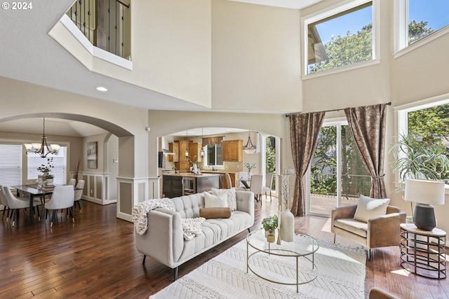 living room featuring a chandelier, a high ceiling, and dark hardwood / wood-style floors