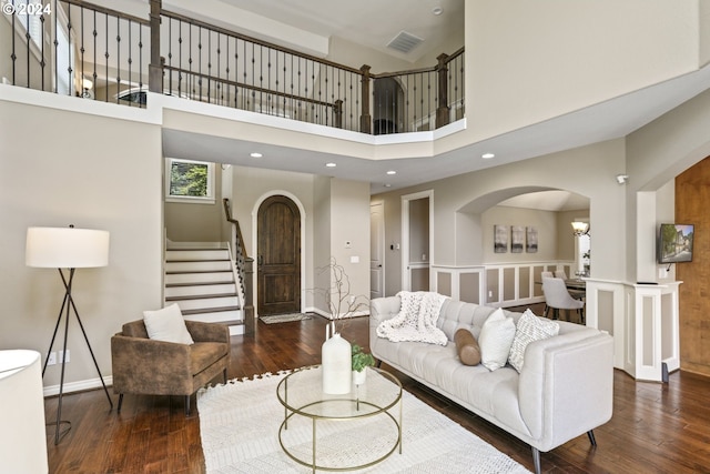 living room featuring dark hardwood / wood-style flooring and a towering ceiling