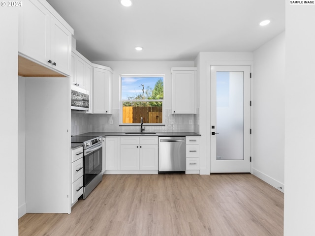 kitchen featuring stainless steel appliances, white cabinetry, light hardwood / wood-style floors, and sink