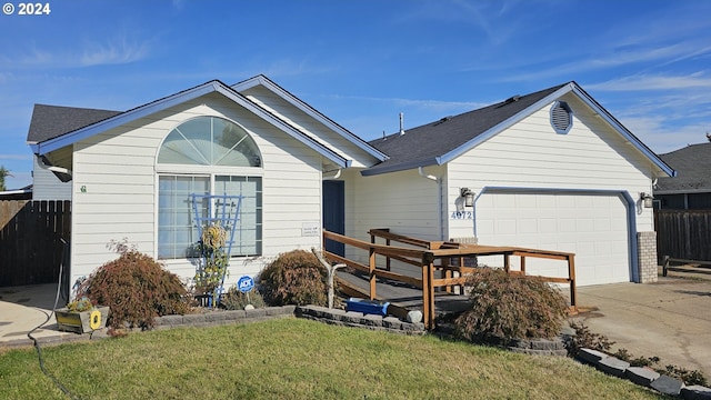 ranch-style house featuring a garage and a front lawn