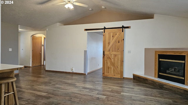 4072 Forsythia St, Springfield, OR 97478 - unfurnished living room with ceiling fan, vaulted ceiling, arched walkways, wood finished floors, and a barn door