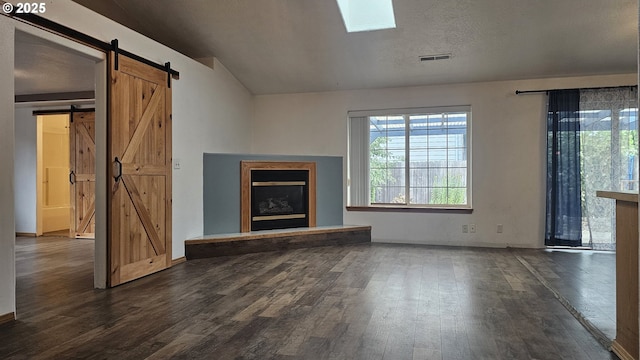 4072 Forsythia St, Springfield, OR 97478 - unfurnished living room with a barn door, a fireplace with raised hearth, dark wood-style flooring, and vaulted ceiling