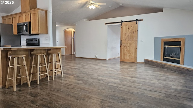 4072 Forsythia St, Springfield, OR 97478 - kitchen featuring stainless steel microwave, lofted ceiling, ceiling fan, arched walkways, and dark wood finished floors