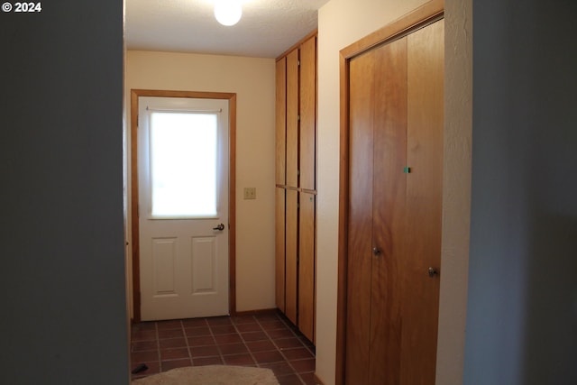 hallway with dark tile patterned floors