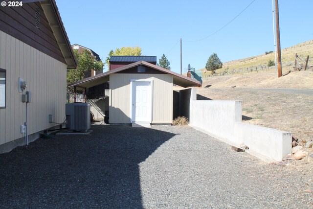 exterior space featuring cooling unit and a storage shed