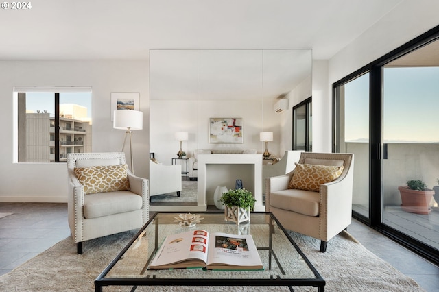 living room featuring an AC wall unit and light tile patterned floors